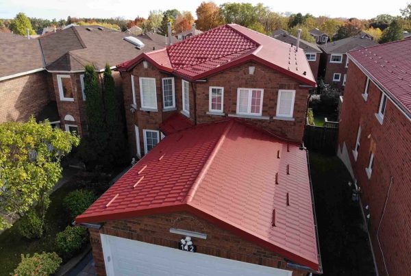 Red metal roof with glossy finish featuring Kynar 500 coating protection.